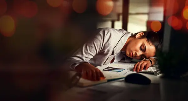 Business woman, sleep and desk in night, tired and bokeh with burnout, stress and deadline in modern office. Accountant, audit and fatigue at desk for proposal, project or rest in dark workplace.