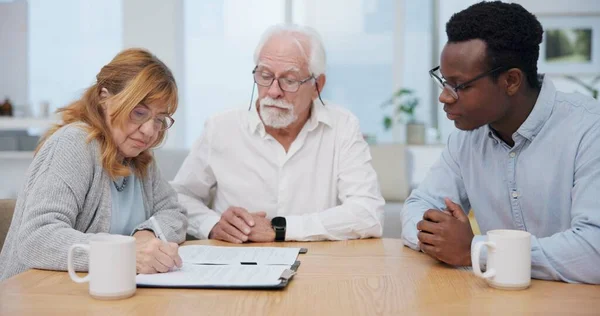Senior couple, insurance and contract with financial advisor and retirement plan to sign. Document, pension and business analyst with information and paperwork in office for signature of will.
