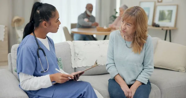 Senior woman with nurse, questions and clipboard with caregiver and elderly care, checklist and health insurance. Medical paperwork, female people and conversation with choice, list and homecare.