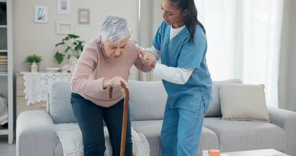 Caregiver support, disabled and old woman with walking stick for help, senior wellness care or old age movement disability. Retirement, nursing home volunteer or nurse helping patient with getting up.