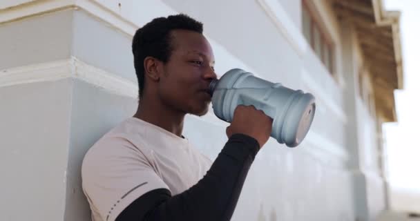 黑人男性 在海滩锻炼 运动或户外运动中喝水和放松身体 因自然营养 饮食或可持续性而休息 休息或饮用矿质液体的疲倦的非洲男性 — 图库视频影像