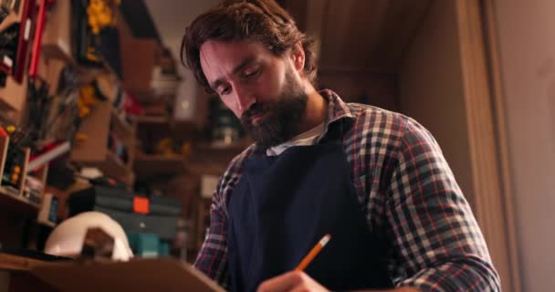 Homem Carpinteiro Escrevendo Checklist Oficina Para Ler Pensar Desenhar Esboço — Vídeo de Stock