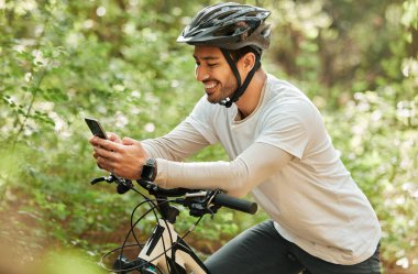 Erkek, orman ve bisikletli telefon, mesajlaşma ve gülümseme doğadaki macera hakkında internet sohbeti bildirimi için. Guy, bisikletle temas kurmak için bisiklet ve akıllı telefon, blogdaki sosyal medya uygulaması ve gevşeme.