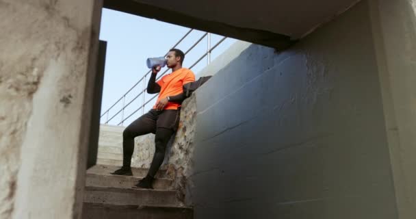 Siyah Bir Adam Içme Suyu Içer Dışarıda Egzersiz Yapar Merdivenlerde — Stok video