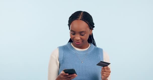 オンラインショッピング Eコマースのお祝い またはスタジオでの支払い成功のための女性の勝者 クレジットカードと電話 モバイルバンキング ローンニュース ブルーバックグラウンドのボーナスのためのダンスに興奮アフリカの人 — ストック動画