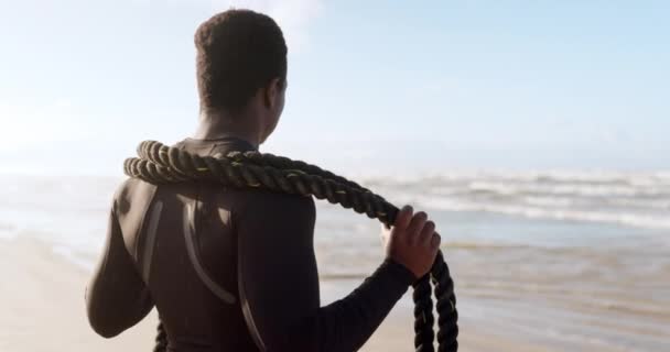 ビーチ ブラックマン フィットネス トレーニング 耐久性 ウェルネスのためのバトルロープ 心臓およびスポーツのための海によるロープが付いている強い アフリカの人かボディービルダー — ストック動画