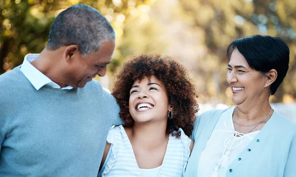 Love, happy and woman with senior parents in an outdoor park for adventure, holiday or weekend trip. Laugh, smile and young female person hugging with her elderly mom and dad in field from Mexico