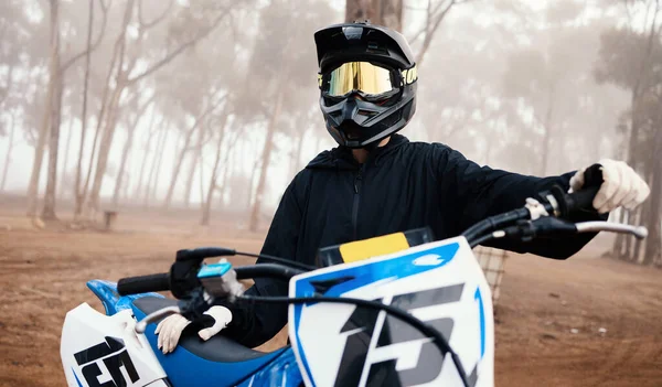Motorcycle, person and sport in forest with training for competition, ride in nature with action and helmet. Extreme, adrenaline and exercise, athlete and transport with dirt bike, freedom and travel.