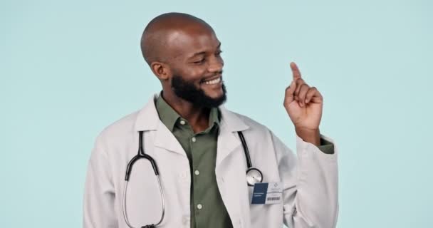 ハッピーブラックマン ドクター 広告を指す スタジオの背景に対するリストや手順 モックアップスペースでアフリカの男性または医療専門家の肖像画 — ストック動画