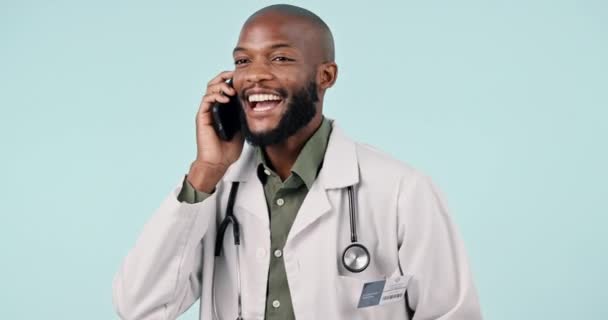 ヘルスケアのためのテレヘルス相談に取り組むスタジオでの電話 男性の医師 ハッピー テクノロジー アフリカの医療従事者 ホワイトバックグラウンドで携帯電話との会話 — ストック動画
