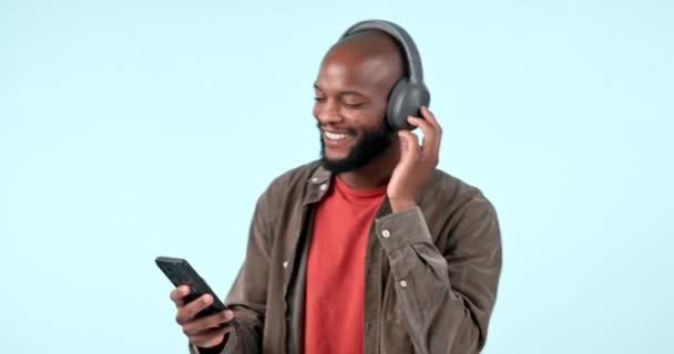 移动应用程序或快乐的黑人男人在蓝色背景的录音室里听着自由的音乐 在线订阅中的广播歌曲 声音或音频流媒体的舞蹈 搜索或非洲人 — 图库视频影像