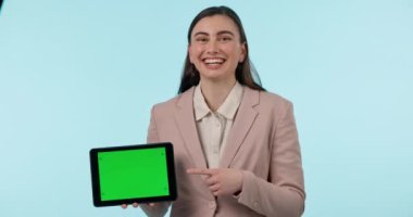 Tablet, yeşil ekran ve stüdyodaki mavi arkaplanı gösteren mutlu bir iş kadını. Teknoloji, web sitesi ve gülümseme ekranda veya ekranda izleme işaretleri gösteren genç bir çalışanla.