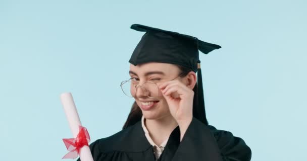 卒業証書 メガネ 幸せな女性ウィンク大学教育 または大学の成功のために 学習成果 スタジオ証明書のスクロール ブルーバックグラウンドの学生フラートの肖像 — ストック動画