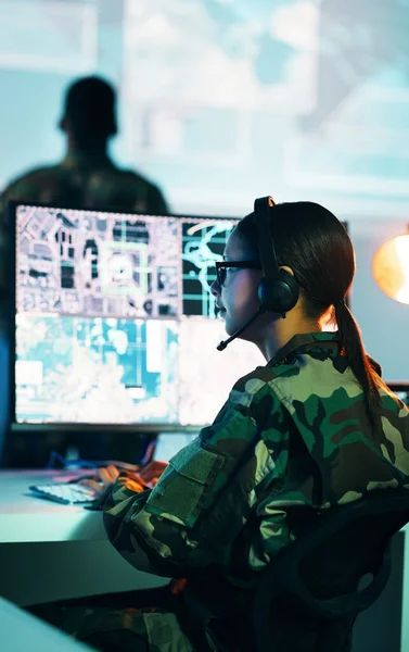 Military control room, computer screen and woman in surveillance, headset and tech for communication. Security, global digital map and soldier at monitor in army office at government command center