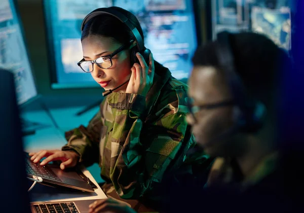Military control room, headset and woman with communication, computer and technology. Security, global surveillance and soldier with teamwork in army office at government cyber data command center