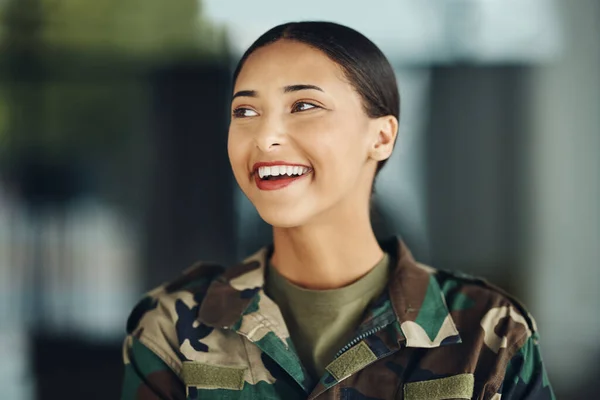 Happy woman soldier with confidence, camouflage and pride, relax outside army building. Professional military career, security and courage, girl in uniform and smile at government agency service
