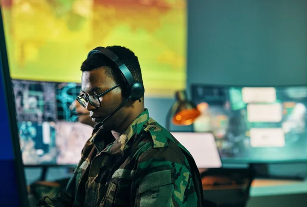 Military, control room and man on computer in office, data center and monitor for technical support, cybersecurity or surveillance. Army, officer and work in tech, security or government communicatio.