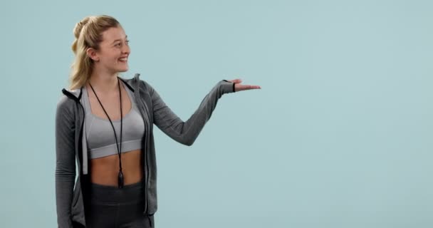 Fitness Sonrisa Mujer Apuntando Palma Estudio Aislado Sobre Fondo Azul — Vídeos de Stock