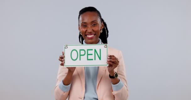 快乐的黑人女人 小公司和开放的标志在模拟空间与工作室的背景 非洲女性的画像 笑着展示广告牌或招贴画 随时准备服务或欢迎 — 图库视频影像