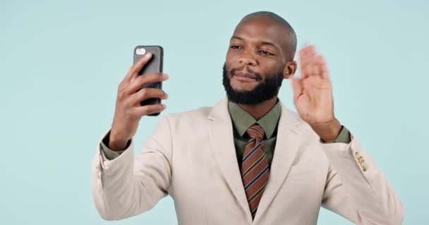 ビジネス ビデオ通話 ブラックマン スマートフォン ブルースタジオのバックグラウンドで挨拶と会計士 アフリカの人 幸せな従業員と携帯電話を持つ投資家 こんにちは 接続との波 — ストック動画