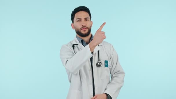 指指点点和工作室里的一个男人 让他做通告 广告或评论 医疗保健工作者快乐 并在蓝色背景上做手势 作为方向 演示或反馈标志 — 图库视频影像