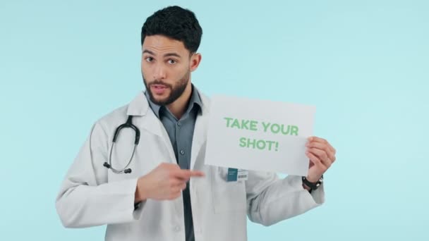 医疗保健 疫苗和一名医生 他在工作室张贴了一张蓝色背景的海报 以寻求医疗建议 一个年轻的医学专业人员展示助推器射击标志的肖像 指点和咨询 — 图库视频影像