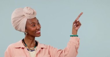 Siyahi kadın, modelleme ve eller satış ve reklam için stüdyoda onaylı olarak ürün yerleştirmeye işaret ediyor. Gülümse, kişi ve mavi arkaplanda satış ya da anlaşma seçeneğini göster.