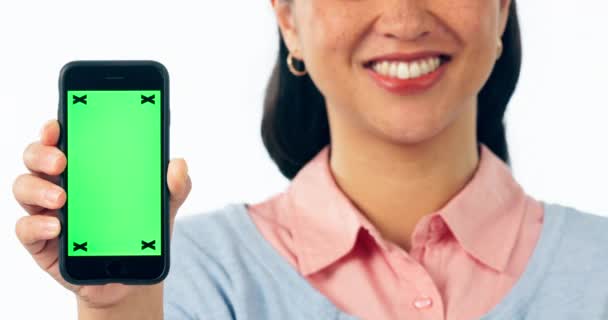 スタジオの背景に対して広告やマーケティングで緑色のスクリーンを持つ幸せな女性 モバイルスマートフォンアプリを表示する女性のクローズアップ 追跡マーカーでモックアップまたは表示 — ストック動画
