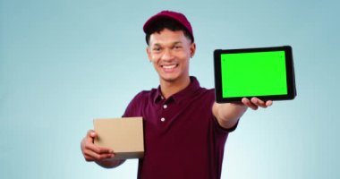 Tablet, yeşil ekran ve teslimatçı stüdyoda karton bir kutu ile ecommerce paketi. İşaretleyiciler, krom anahtar ve dijital teknolojili erkek kurye mavi arkaplanlı model uzayı