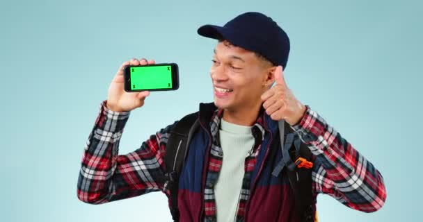 緑のスクリーン スマートフォン付きの男 ブルースタジオの背景に親指とバックパッカー ポートレート ハイカー 携帯電話付きの人 サポートと笑顔でマーカーと手のジェスチャーを追跡 — ストック動画