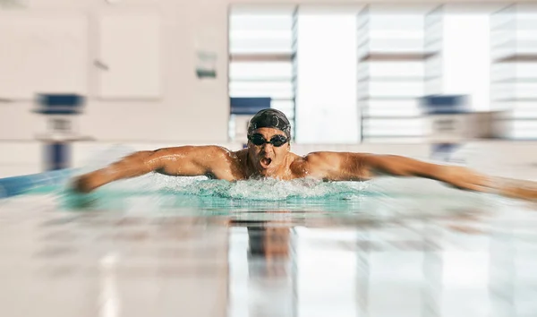 Swimming action, pool and sports man doing water challenge, cardio training or butterfly stroke action. Motivation, speed blur and swimmer workout, practice or training for competition, match or race.