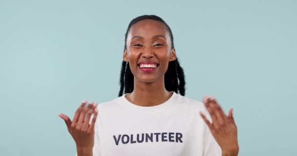 志愿者 T恤和一个在演播室里手握手势的女人打电话或邀请她参加社区服务 面对一个有着蓝色背景的快乐黑人的志愿工作 招募和问责制度 — 图库视频影像