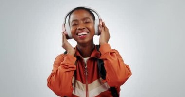Siyahi kadın, kulaklıklar ve müzik, eğlenceli, enerjik dans eden öğrenci ve beyaz arka planda radyo dinliyor. Teknoloji, model uzay ve dansçı stüdyoda, ses yayını ve üniversitede tekno ses..