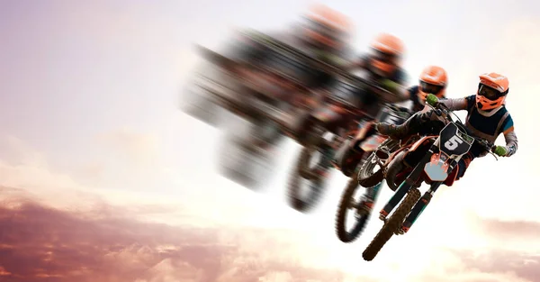 Motorcycle, double exposure and motion blur with a sports person in the air during a jump at a race course. Bike, training and energy with an athlete on a cloudy sky for speed, power or freedom.