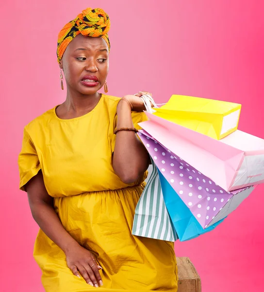 Studio bag, shopping problem or black woman with bad shop product, boutique crisis or shopaholic. Facial expression, mistake or African customer disappointed with retail present on pink background.