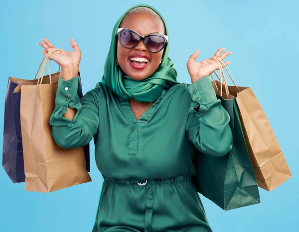 Shopping bag, studio and black woman excited for fashion spree, mall store sales or boutique deal, giveaway or shop offer. Retail therapy gift, choice and wealthy African customer on blue background.
