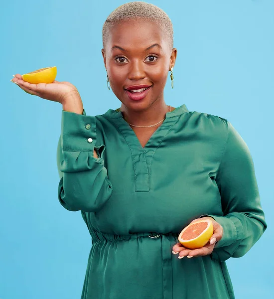 Black woman, portrait and orange for vitamin C in diet, natural nutrition or detox against a studio background. Happy African female person smile with healthy organic citrus fruit for body wellness.