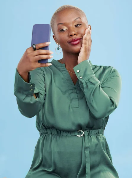 賞金とスタジオブルーの背景で隔離されたモバイルアプリビデオ通話のためのスマイル セルフィー 幸せな黒人女性 ソーシャルメディアでのコネクション 落ち着いた人 コンテンツクリエイター インフルエンサーのライブストリーミング — ストック写真