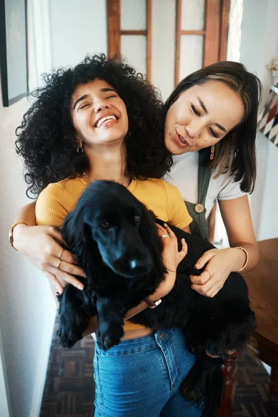 Dog, hug and happy lesbian couple in home, bonding or having fun together. Pet, gay women smile and embrace animal for care in healthy relationship, love connection and funny laugh of lgbtq people.