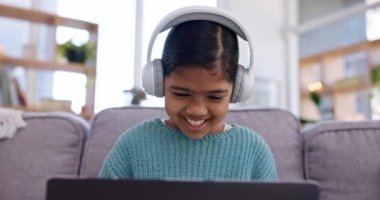 Kız, çocuk ve dizüstü bilgisayar, kulaklık ve oyun çevrimiçi evde teknolojili film izlemek ya da canlı yayın. Video oyunları, müzik dinlemek veya eğlence, abonelik ve ses ile elde etmek.