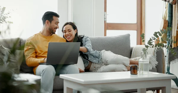 Couple, laptop and laugh on sofa in home for meme, watch movies and streaming funny multimedia. Happy man, woman and relax at computer in living room on social media, web subscription or comedy show.
