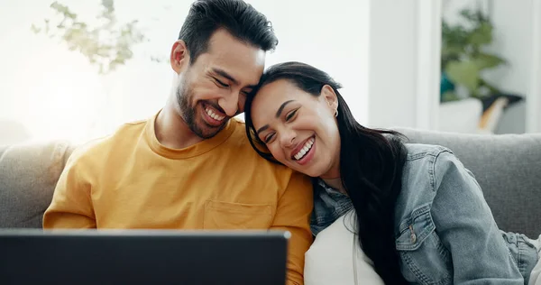 Happy couple, laptop and relax in home for love, watch comedy movies or scroll website for online shopping. Man, woman and laugh for funny joke on computer, social media subscription and meme on sofa.