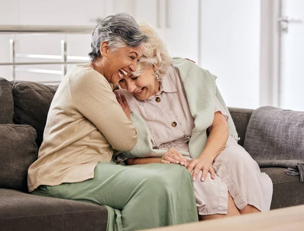 Funny senior women on sofa, friends bonding and relax in home together. Elderly people on couch laughing at joke, comedy or humor in lounge, having fun conversation and retirement chat in living room.