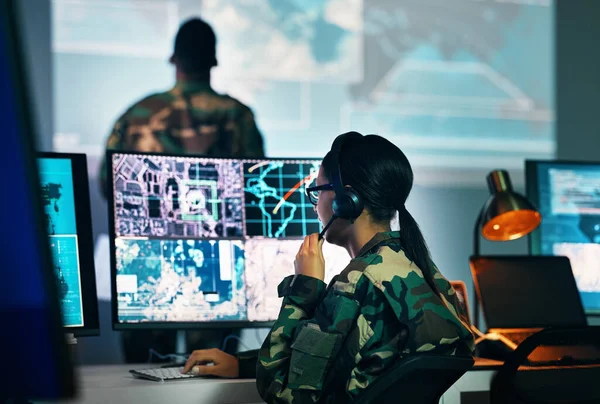 Military command center, computer screen and woman in surveillance, headset and tech for communication. Security, world satellite map and soldier at monitor in army office at government control room