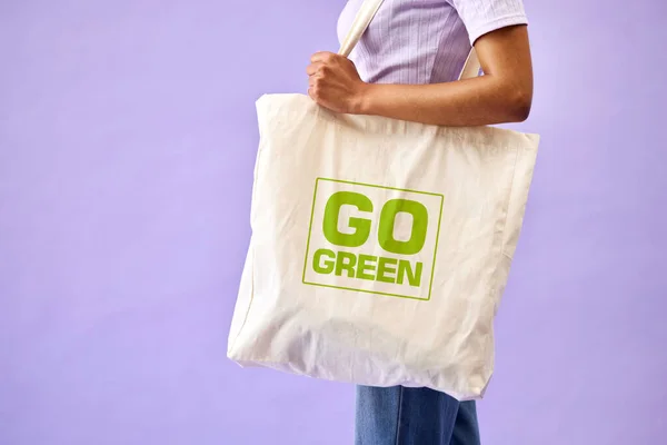 Sustainable, shopping and eco friendly bag by person or recycling customer isolated in a studio purple background. Environment, retail and woman with carbon footprint, zero waste and grocery.