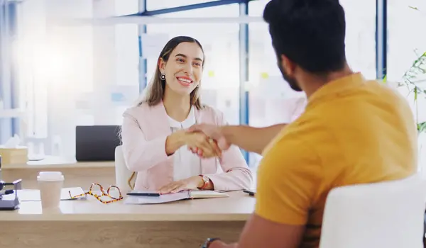 Laughing, business people and handshake for partnership, deal or introduction in workplace. Funny, man and woman shaking hands for agreement, b2b or onboarding, congratulations or welcome to company