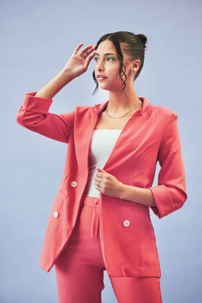 Fashion, suit and woman in studio thinking, confidence and body in beauty aesthetic. Makeup, style and influencer girl in designer clothes, trendy promo or confident model standing on blue background.