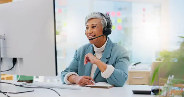 Consultant, senior woman and talking with technology at office for customer service at help desk call center. Sales, telemarketing and mature employee with headphones at work for crm with technical s.