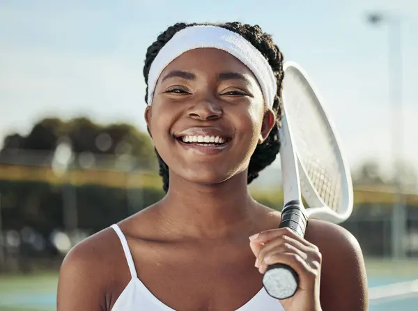 Sports, smile and portrait of woman tennis player with a racket practicing to play a match at stadium. Fitness, happy and young African female athlete with equipment training on court for tournament