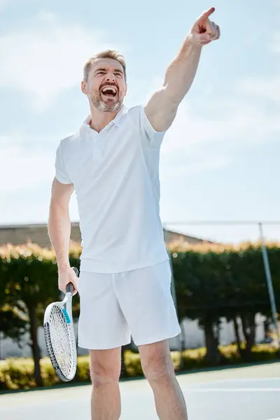 Tennis, point and game with a sports man on a court, playing a match for competition in summer. Racket, ball and winner with a mature athlete outdoor for fitness, training or hobby for recreation.